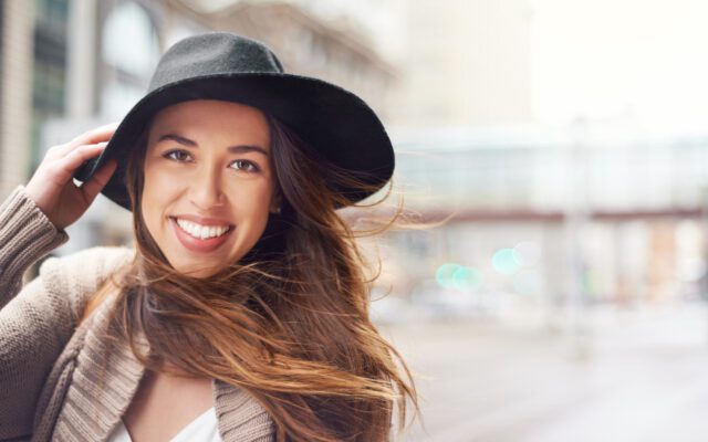 Shot of a young woman out for a walk on a windy day in the city